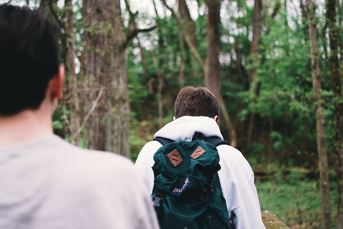 Parent hiking on a forest trail with a baby in a structured child carrier