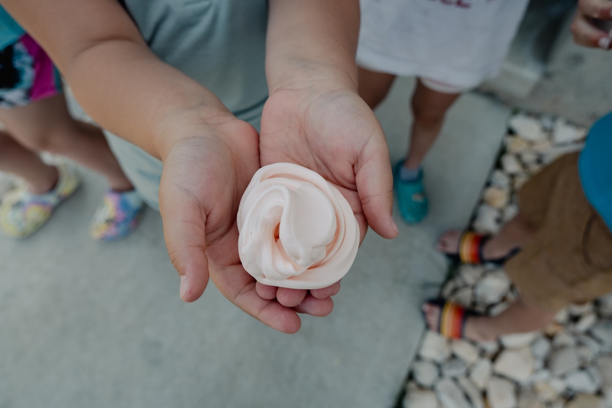 A toddler engaged in hands-on sensory play outdoors, digging in dirt with curiosity and focus